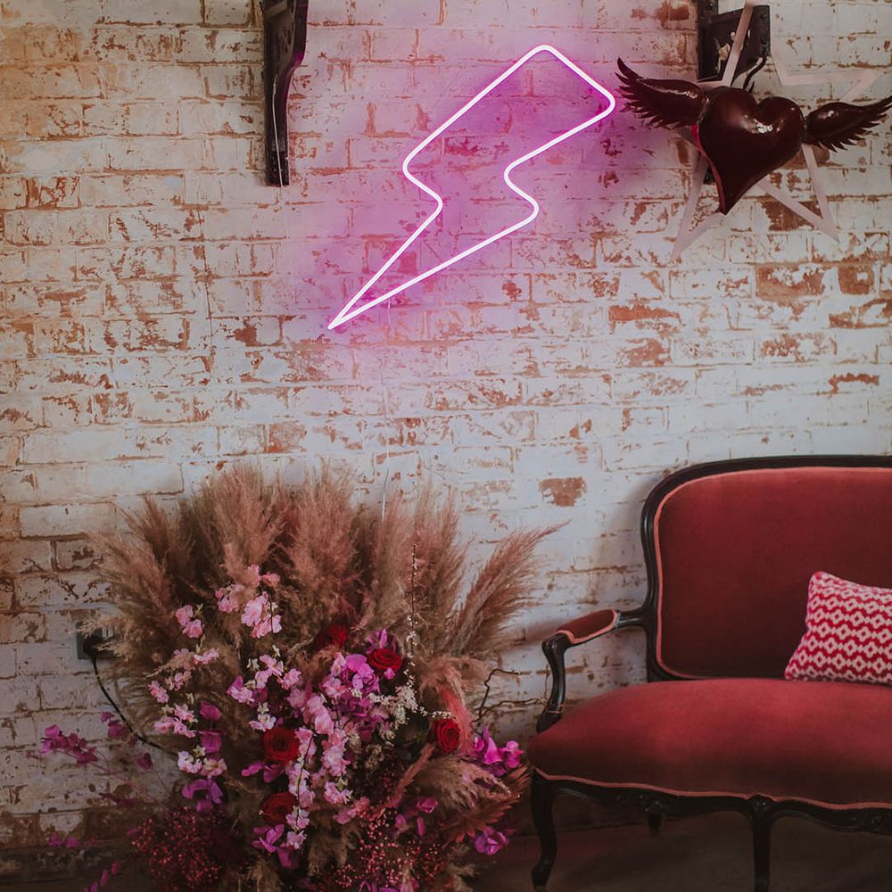 Pink velvet couch, pink neon lightning sign and quirky heart wedding decor at Prestwold Hall Barn 
