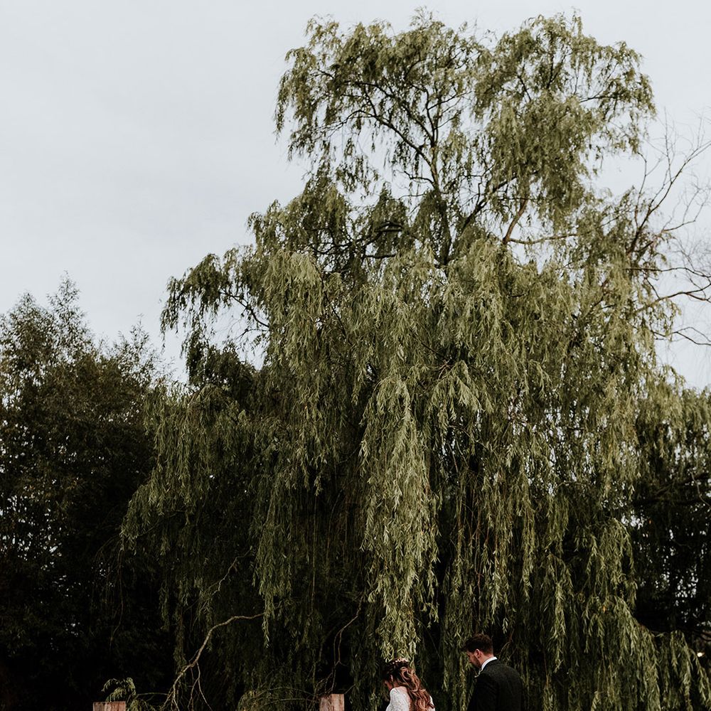 Bride and groom walk together around the grounds of Silchester Farm wedding venue