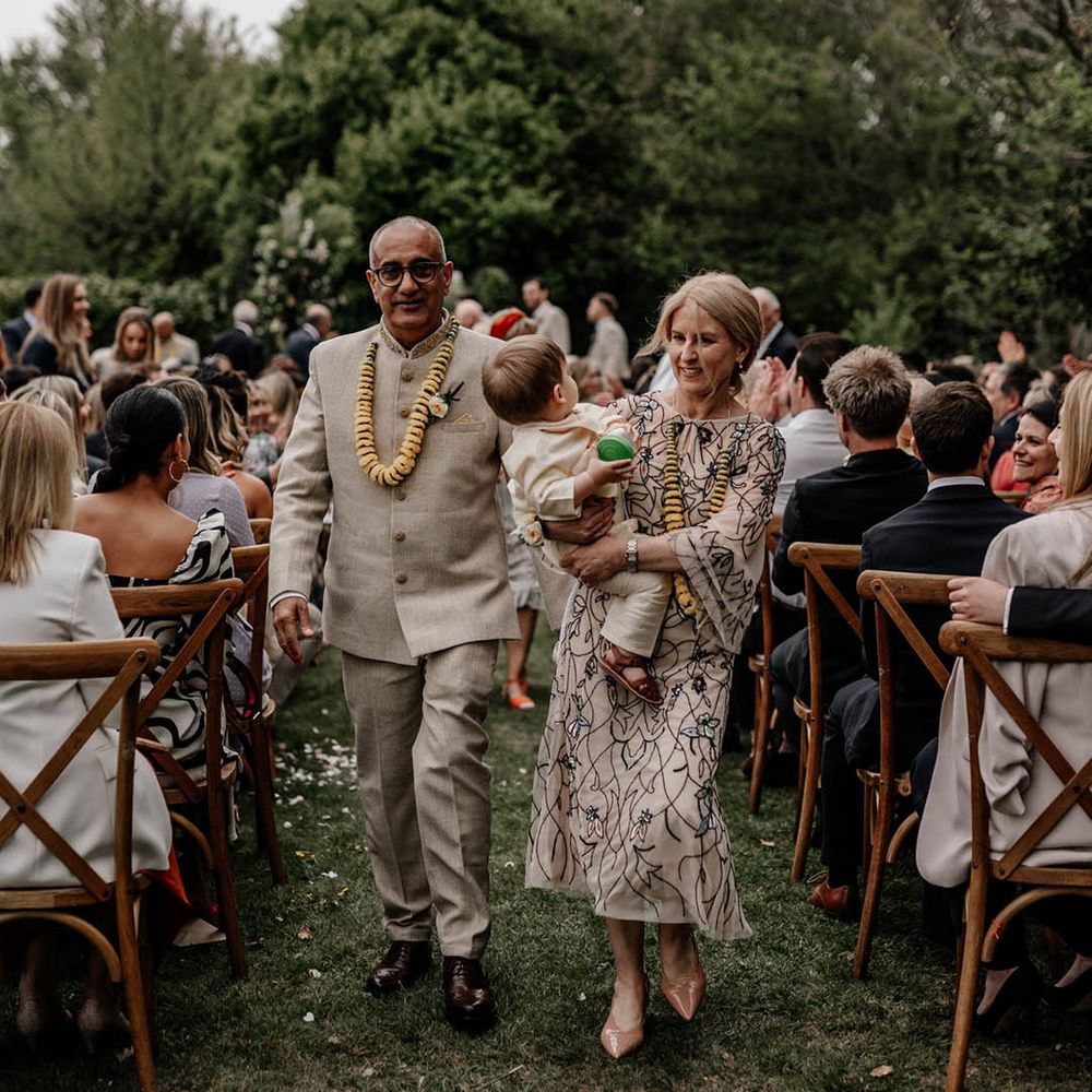 Mother and father of the bride descending up the aisle with their grandson