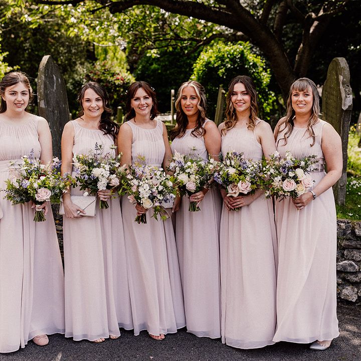 Bridesmaids in blush pink chiffon bridesmaid dresses with pink, purple and white spring bouquets 