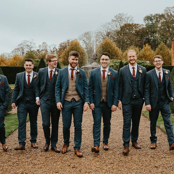 Groom with groomsmen in blue suits and orange ties for the autumn wedding 