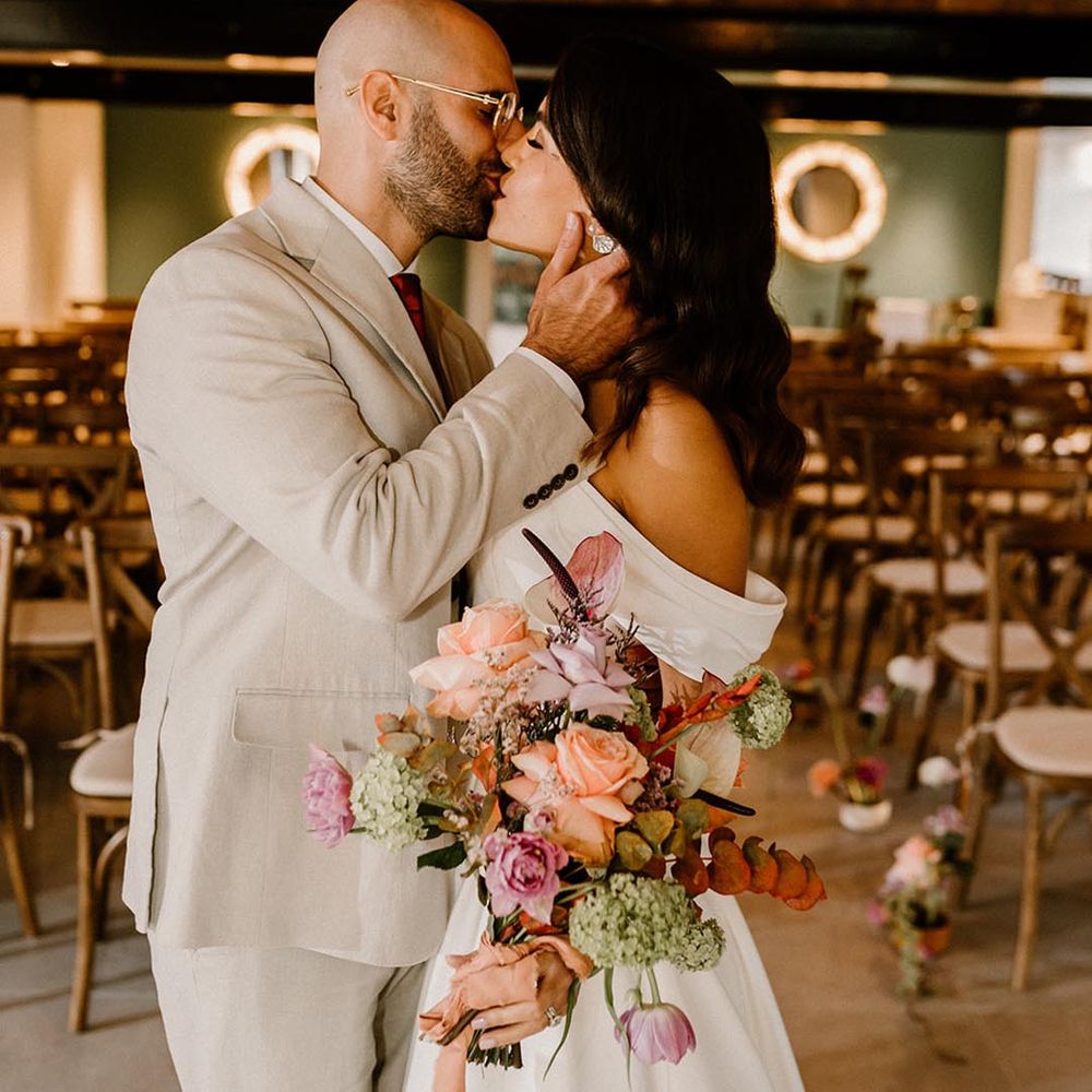 Bride and groom share their first kiss as a married couple for their autumnal wedding 