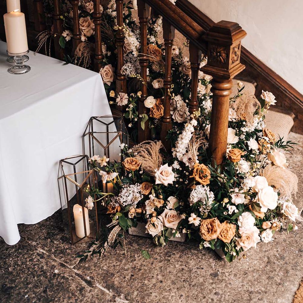 Neutral toned rose and foliage display on the staircase of Pennard House