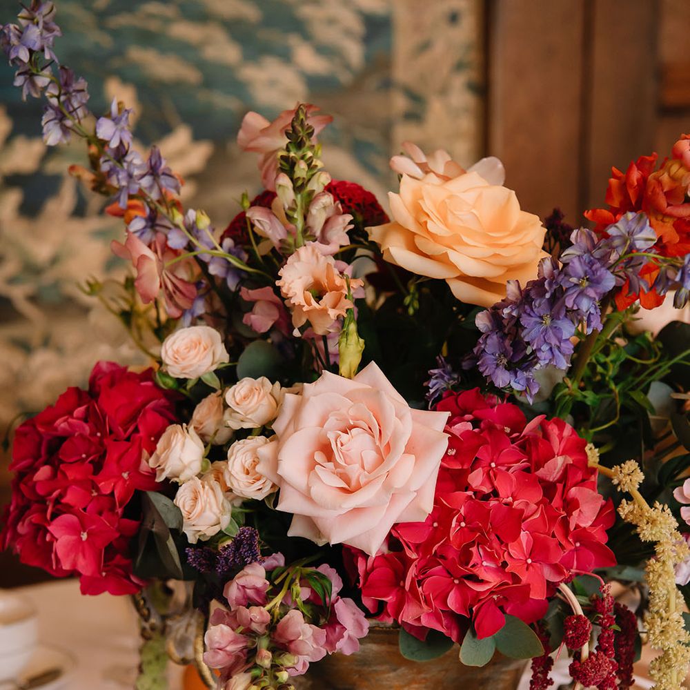 Red, purple, pink, and light peach wedding flowers with hydrangeas and roses 