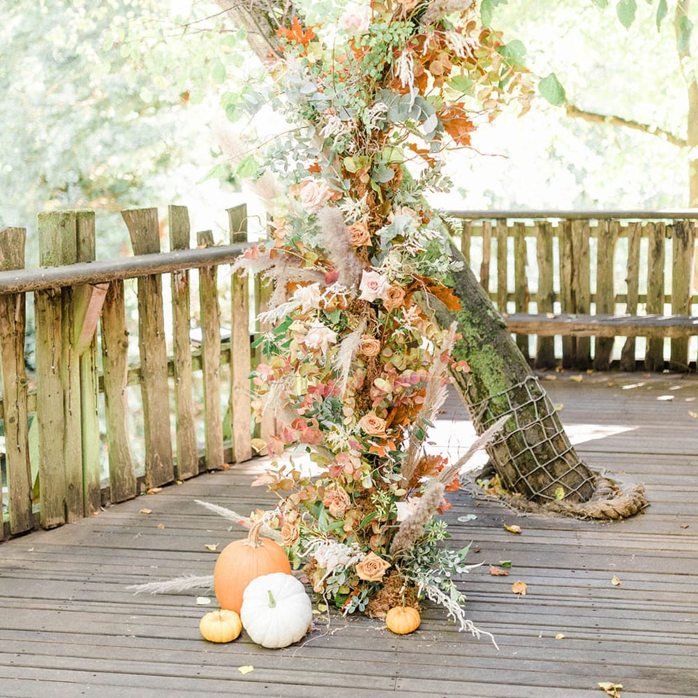 Dried floral column beside tree complete with pumpkin decor to the bottom at Alnwick Garden Treehouse