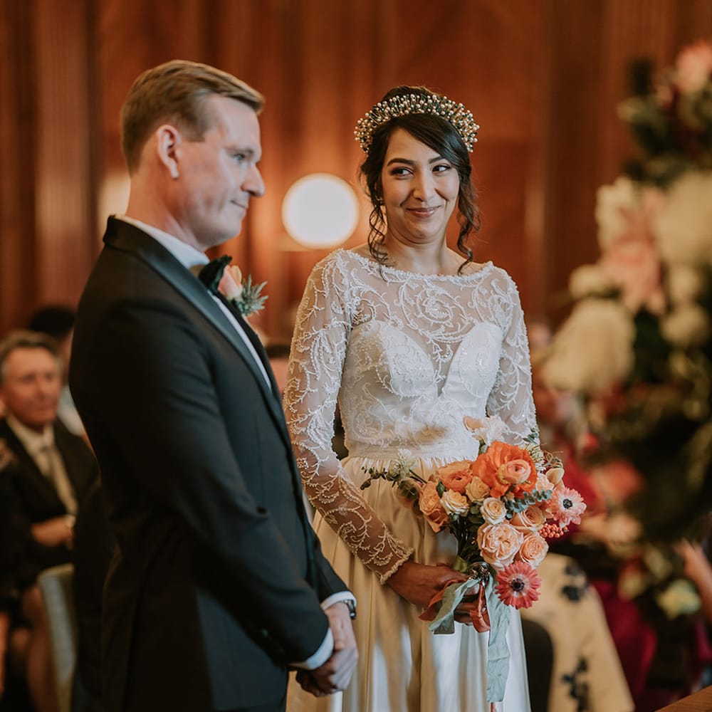 Bride and groom standing at the alter of multicultural Christmas wedding with a Lion Dance and disco decorations
