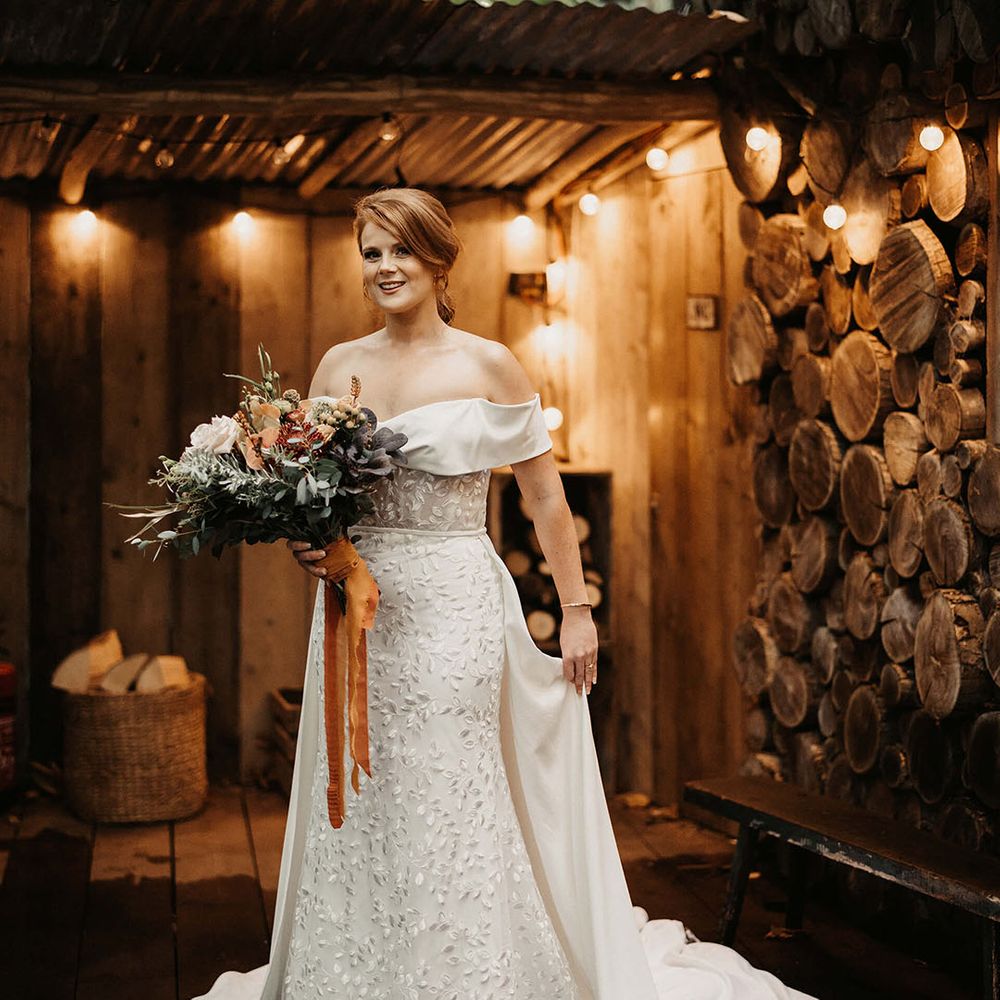 Bride wears Love Spell wedding dress with embroidered floral design and white skirt to back