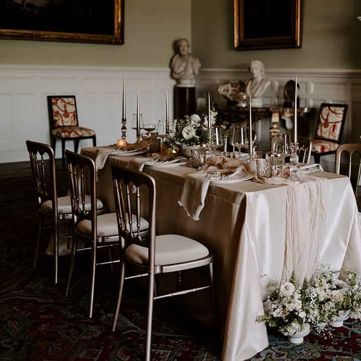 intimate wedding reception at Capesthorne Hall with gold rimmed glassware and tablecloth