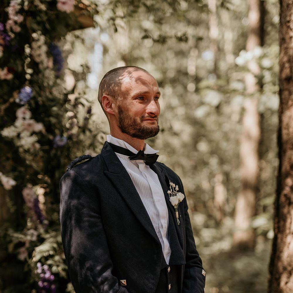 Camp Katur wedding in a woodland with the groom in green checkered wedding trousers with white rose buttonhole 