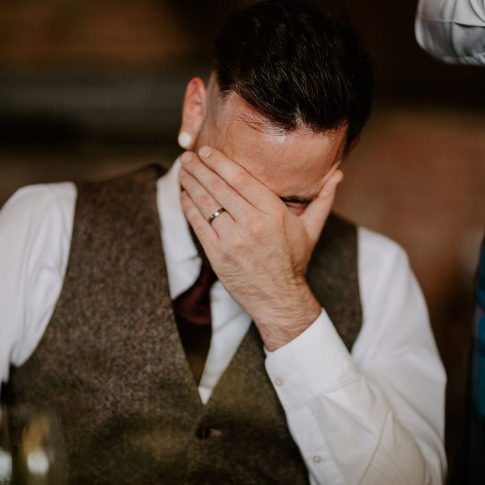 Groom hides his face as he reacts to the wedding speeches 