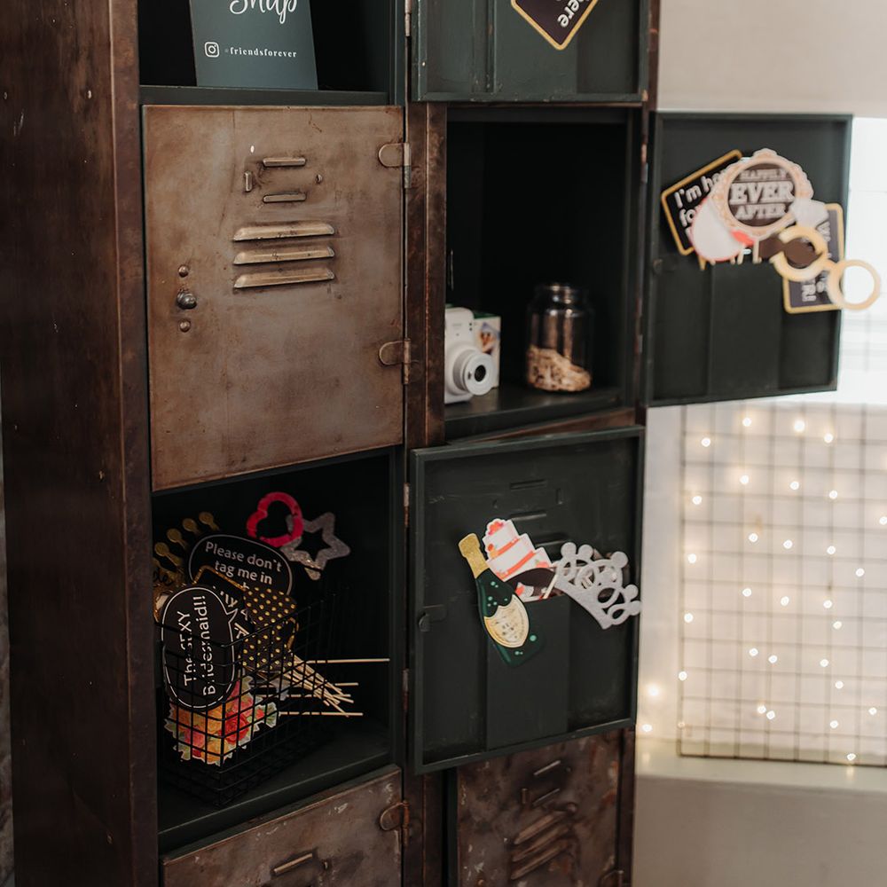 Photo booth props in industrial style lockers for the guests to take photos with for the guest book 