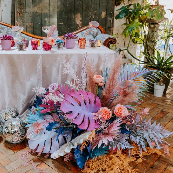 Sweetheart table at festival wedding with holographic pastel wedding decor and flowers 
