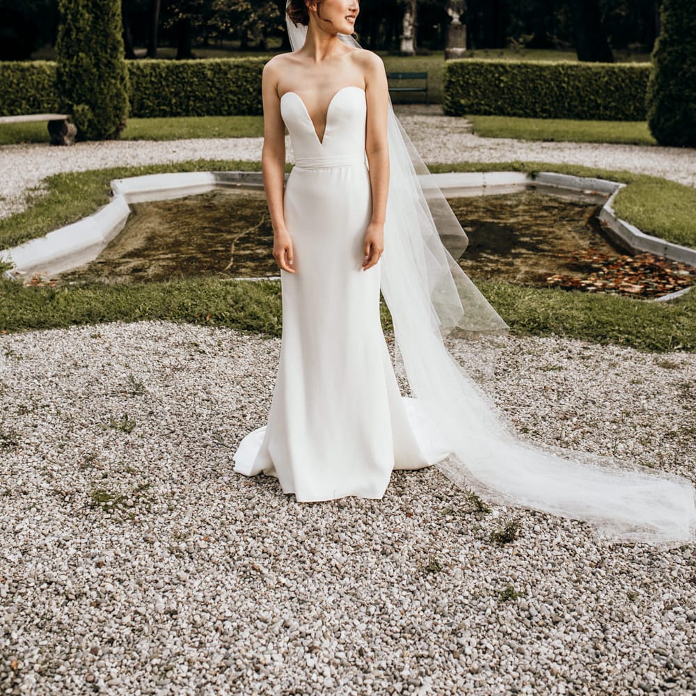 Asian bride in off the shoulder Reem Acra wedding dress and cathedral length veil 