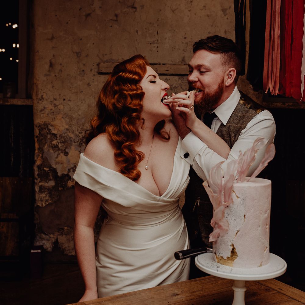 Bride and groom feeding cake to each other at their Micro wedding 