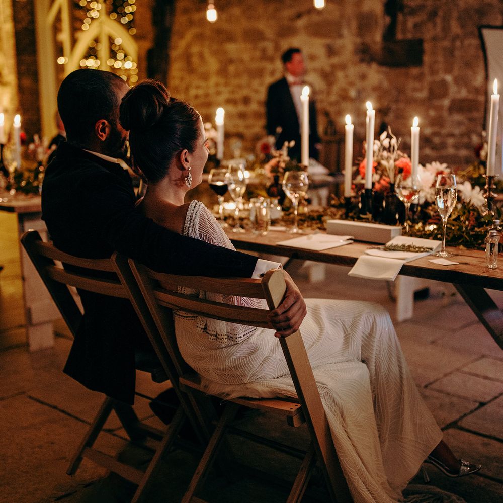 Wedding reception venue at night with lit candles and rustic styling