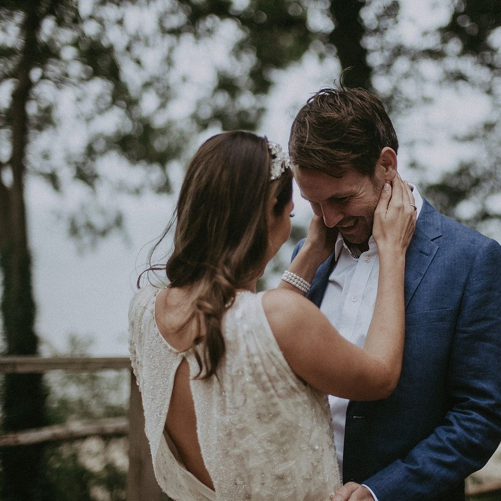 Bride wraps arms around grooms neck on their wedding day
