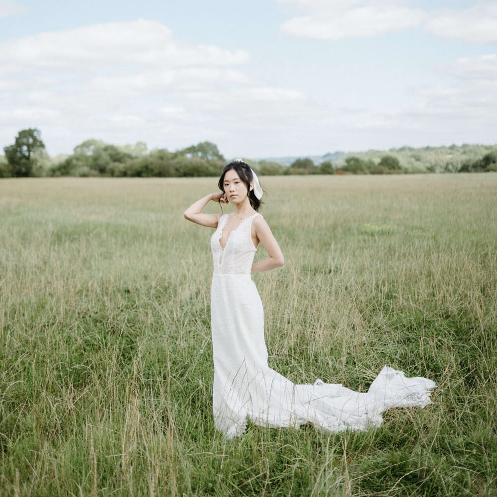 Bride in the fields of Berwick Lodge wearing plunge neck boho wedding dress with floral bodice and tulle skirt