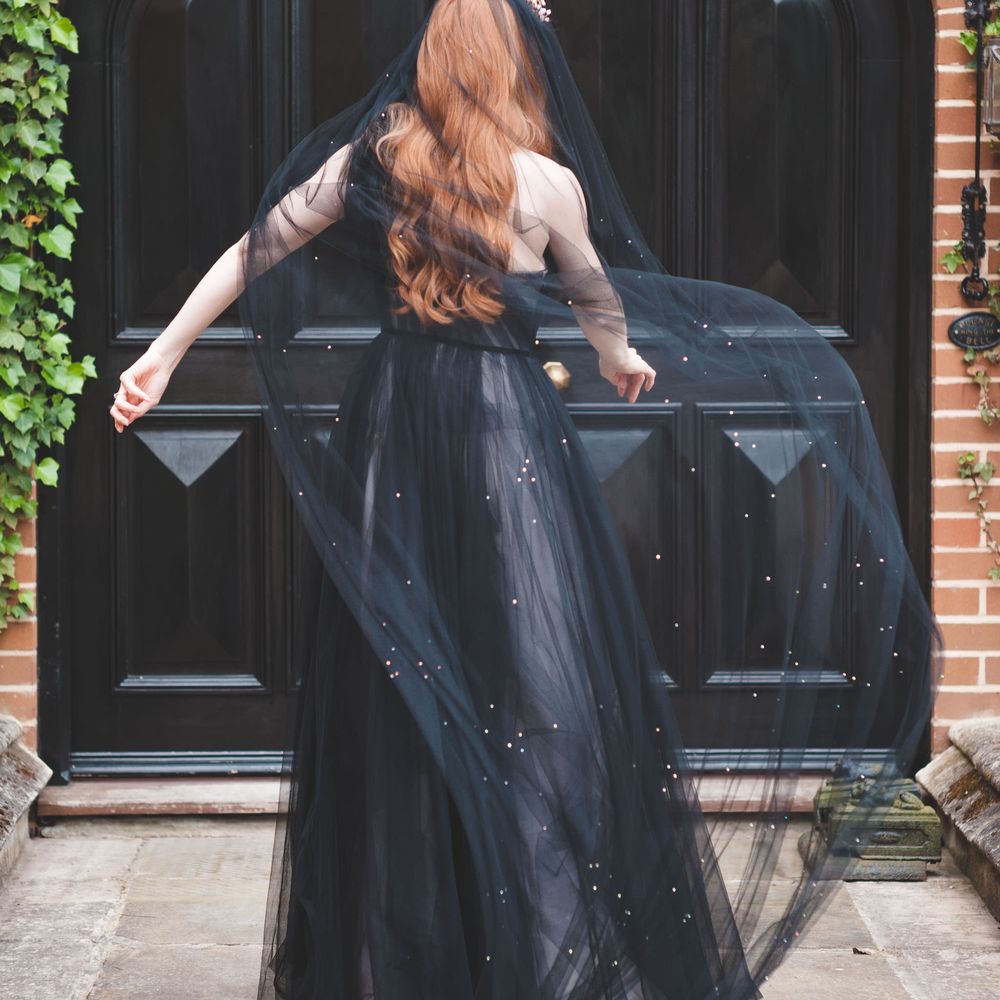 Bride in a one shoulder black tulle wedding dress with dramatic black veil at autism marriage wedding inspiration