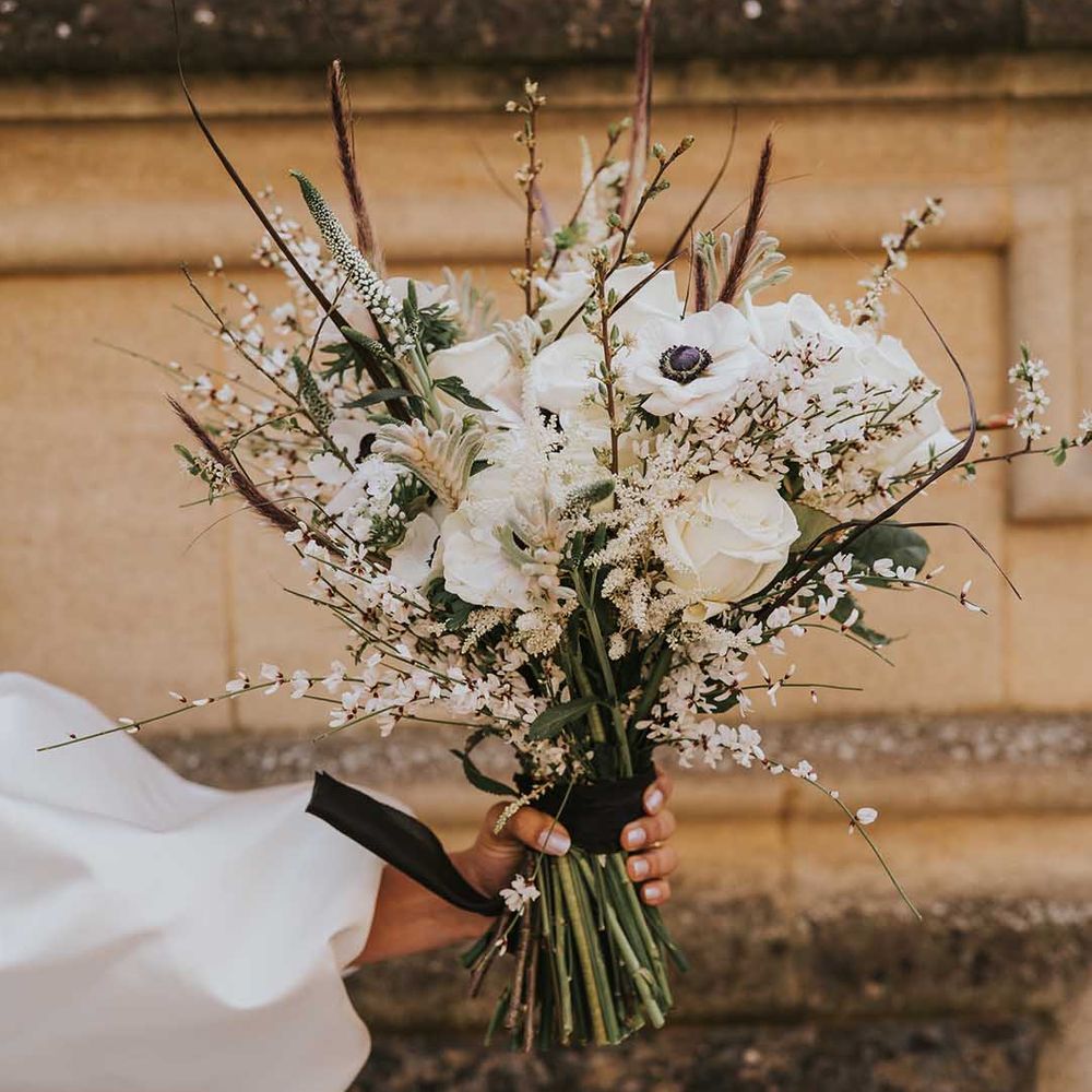Winter white wedding bouquet with roses, anemones and astilbe