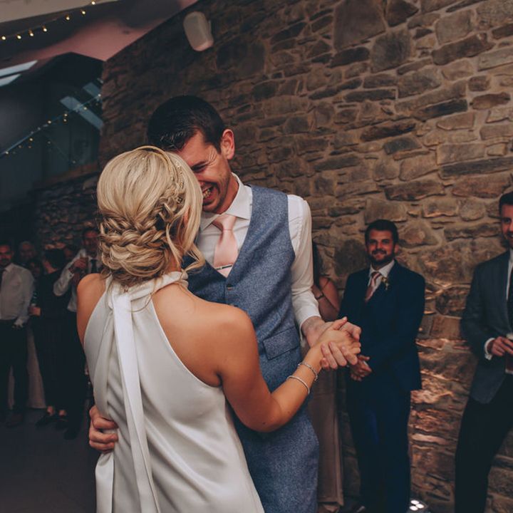 Bride with braided updo dances with new husband