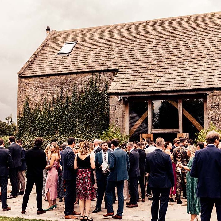 Wedding guests gather outside the Stone Barn Cotswolds for rustic wedding