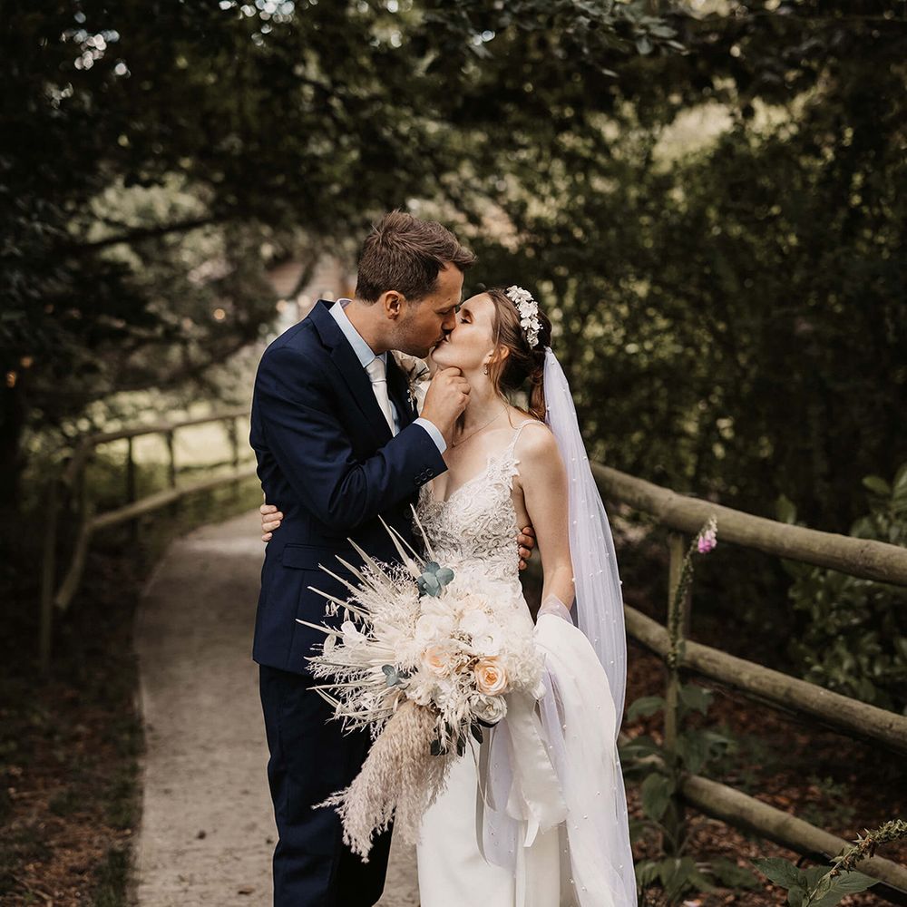 Bride & groom kiss outdoors on their wedding day