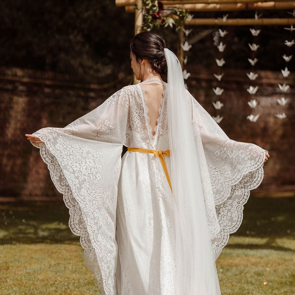 East Asian bride in a lace Kimono style wedding dress with long sleeves and yellow dipped long veil