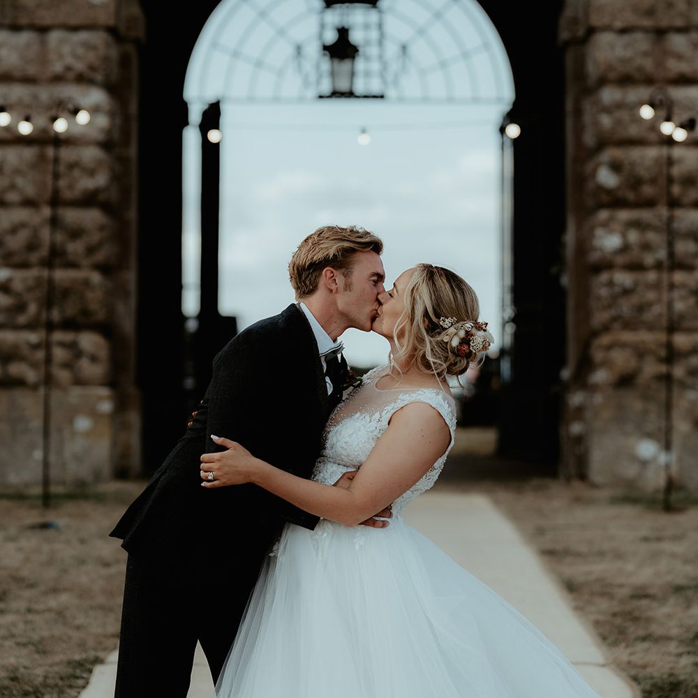 Bride and groom share a kiss for their marquee reception at the stunning Badminton Estate