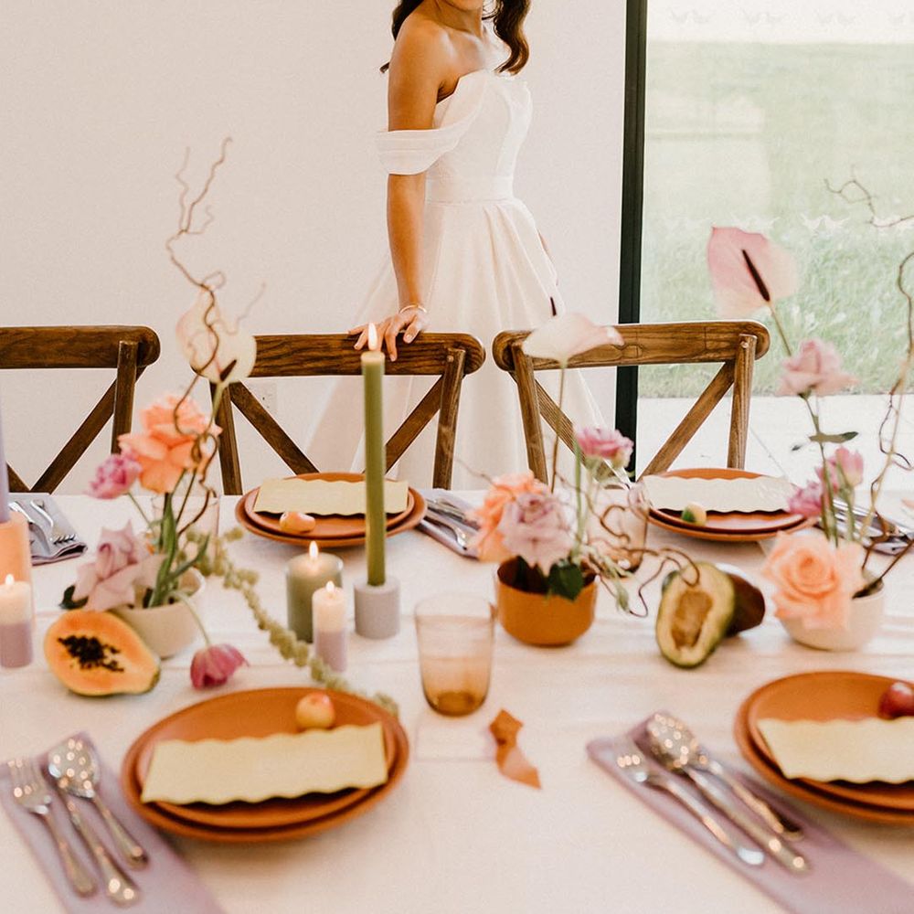 Pastel purple and green wedding table setting with terracotta plates and fruit decor 