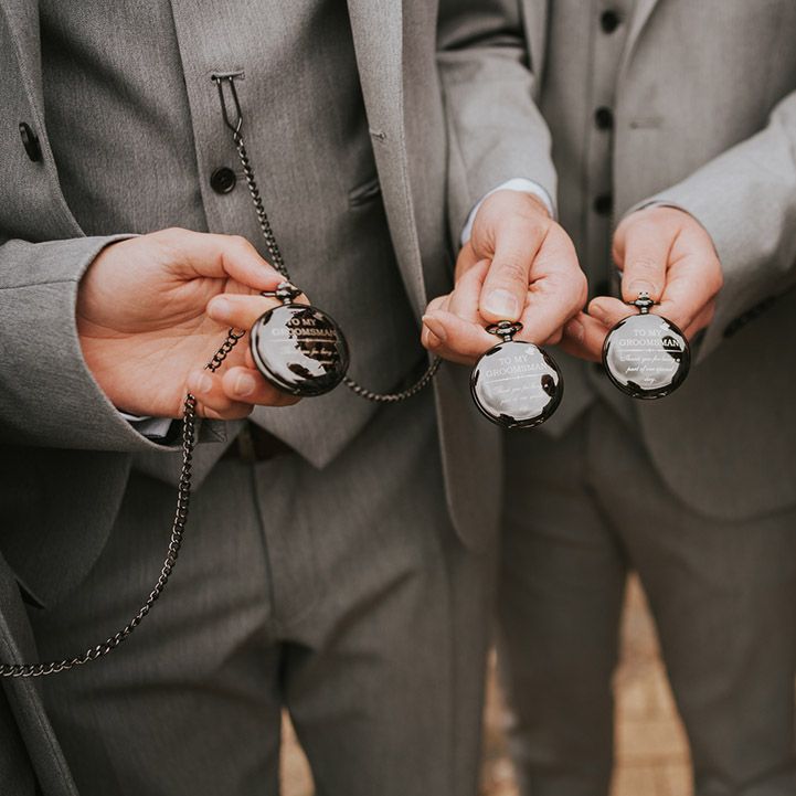 Custom black and gold pocket watches gifted to the groomsmen for the wedding day 