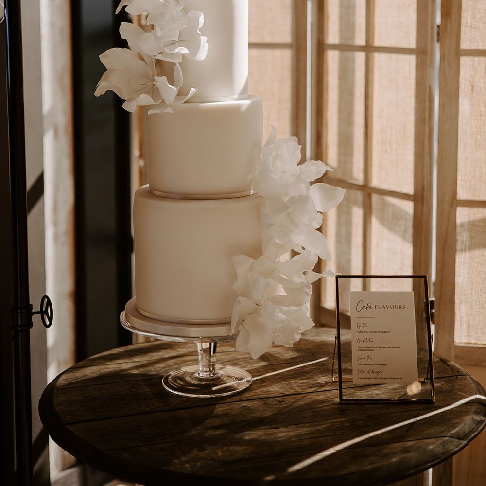Three tier wedding cake with white frosting and modern floral sugar design 