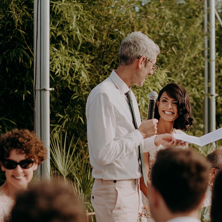 Groom looking at a smiling Bride while he reads his wedding speech