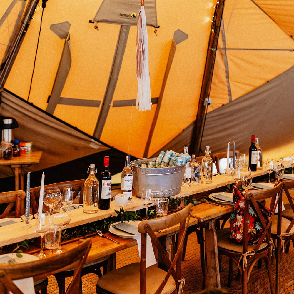 Tipi wedding reception with ballon table signs with tassels and plenty of alcohol for the wedding guests with gin stations