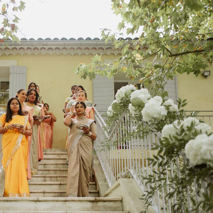 wedding party in different sari's holding baskets of petals at outdoor Provence wedding