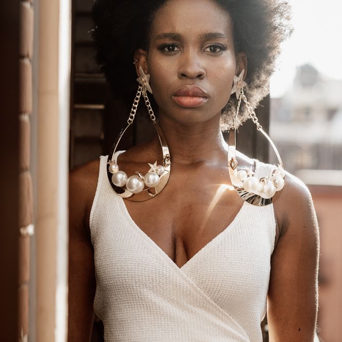Bride in white strappy top with large golden earrings 