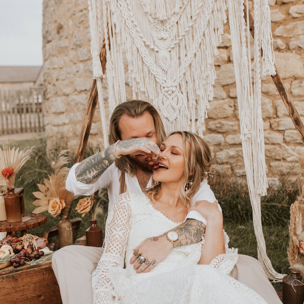 Bride & groom sit outside for outdoor picnic 