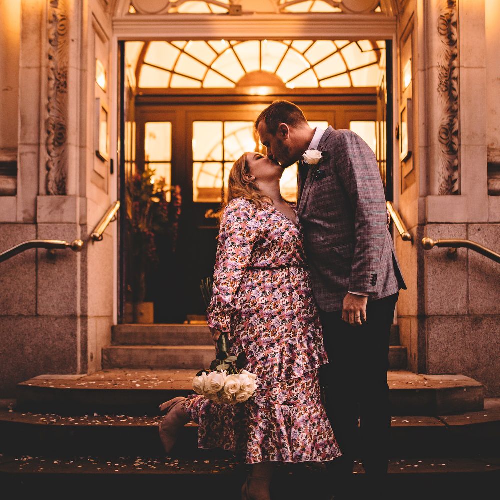 Bride & groom kiss on the steps of Chelsea Old Town Hall on the day of their wedding