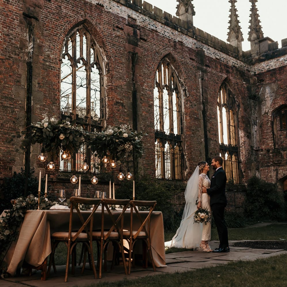 Intimate tablescape with festoon lights and foliage installation at the Bombed Out Church in Liverpool 