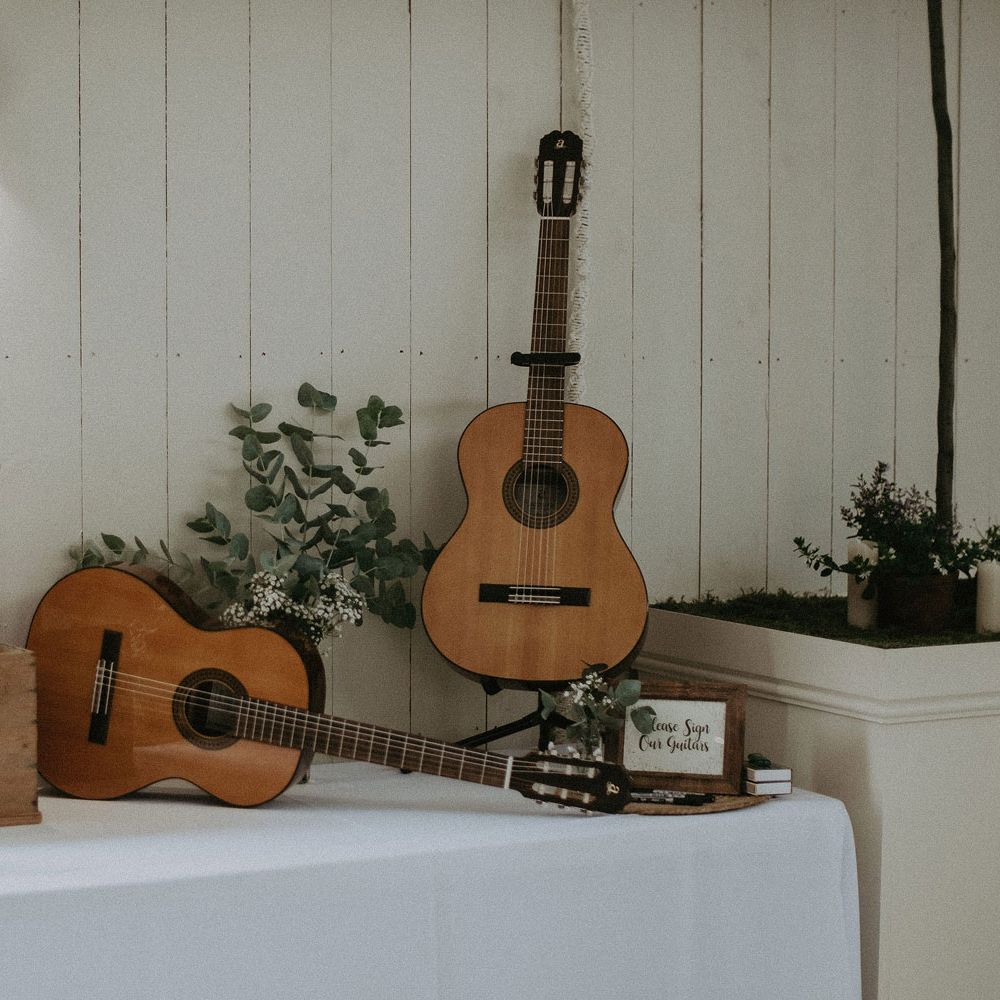 White table with card box, foliage decor and and guitar wedding guestbooks for Isle of Wight wedding with macrame wedding decor