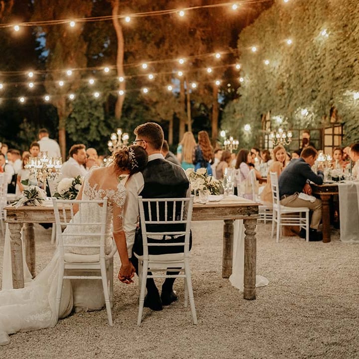 Fairy light canopy hangs above tables during outdoor wedding reception in Italy | Royal Studio