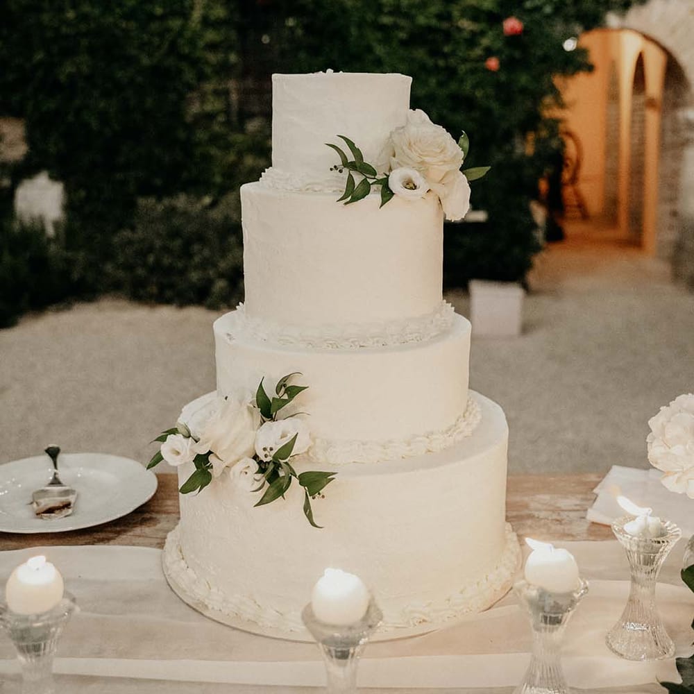 White 4 tier wedding cake complete with floral decor  | Royal Studio