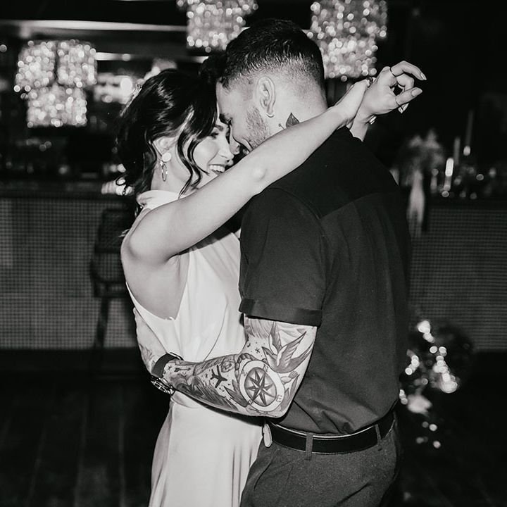 Black and white portrait of the bride and groom doing their first dance at their city bar wedding 