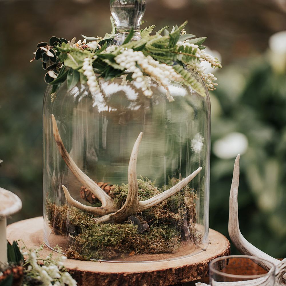 glass cloche wedding decor on a rustic tree slice with moss and antlers 