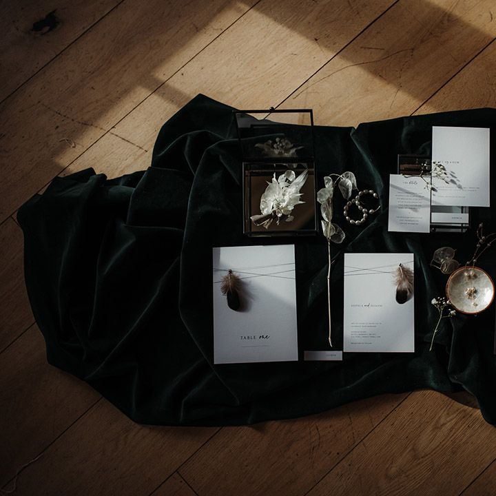 Flatlay of a white stationery suite on a black table cloth 