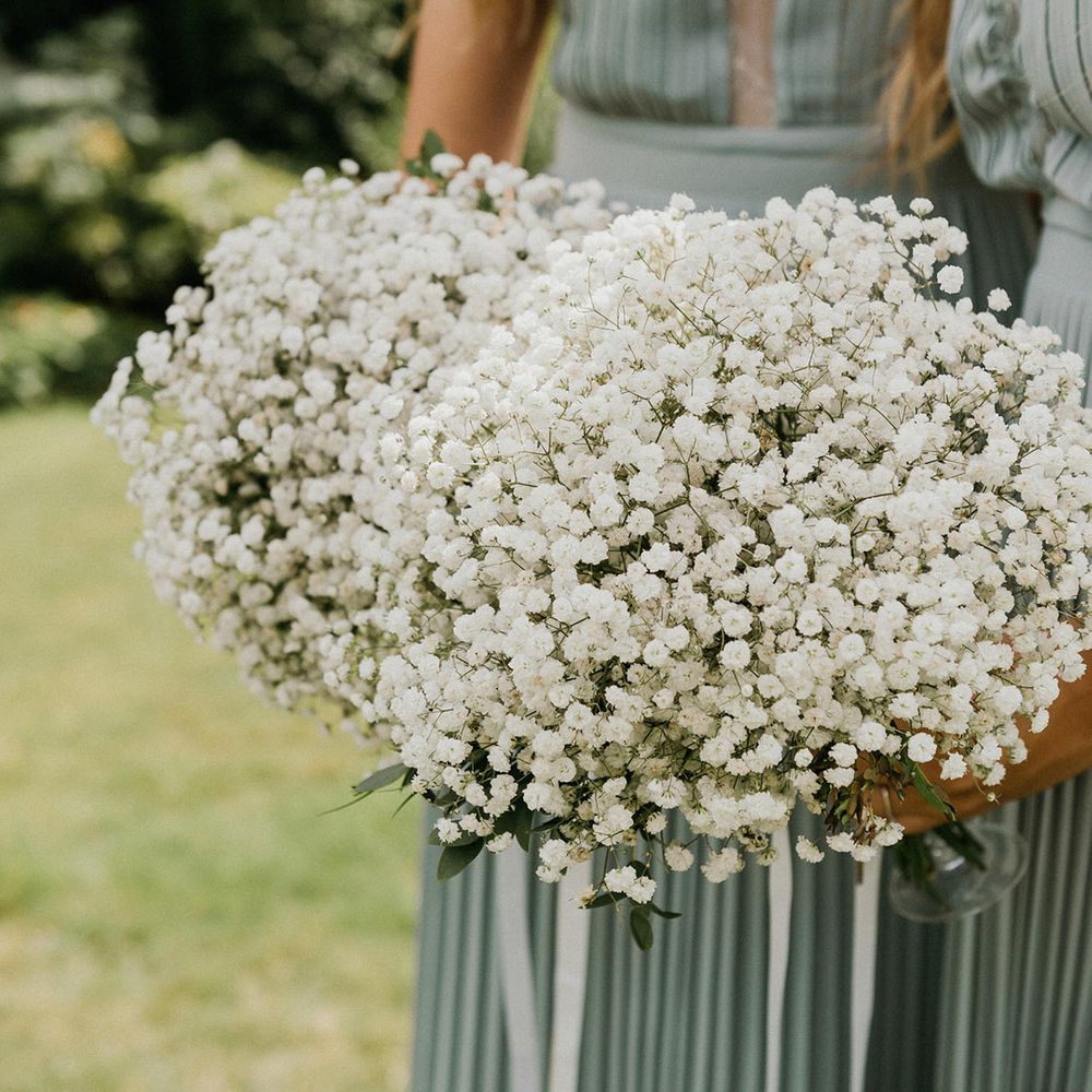Bridesmaids hold matching gypsophila bouquets 