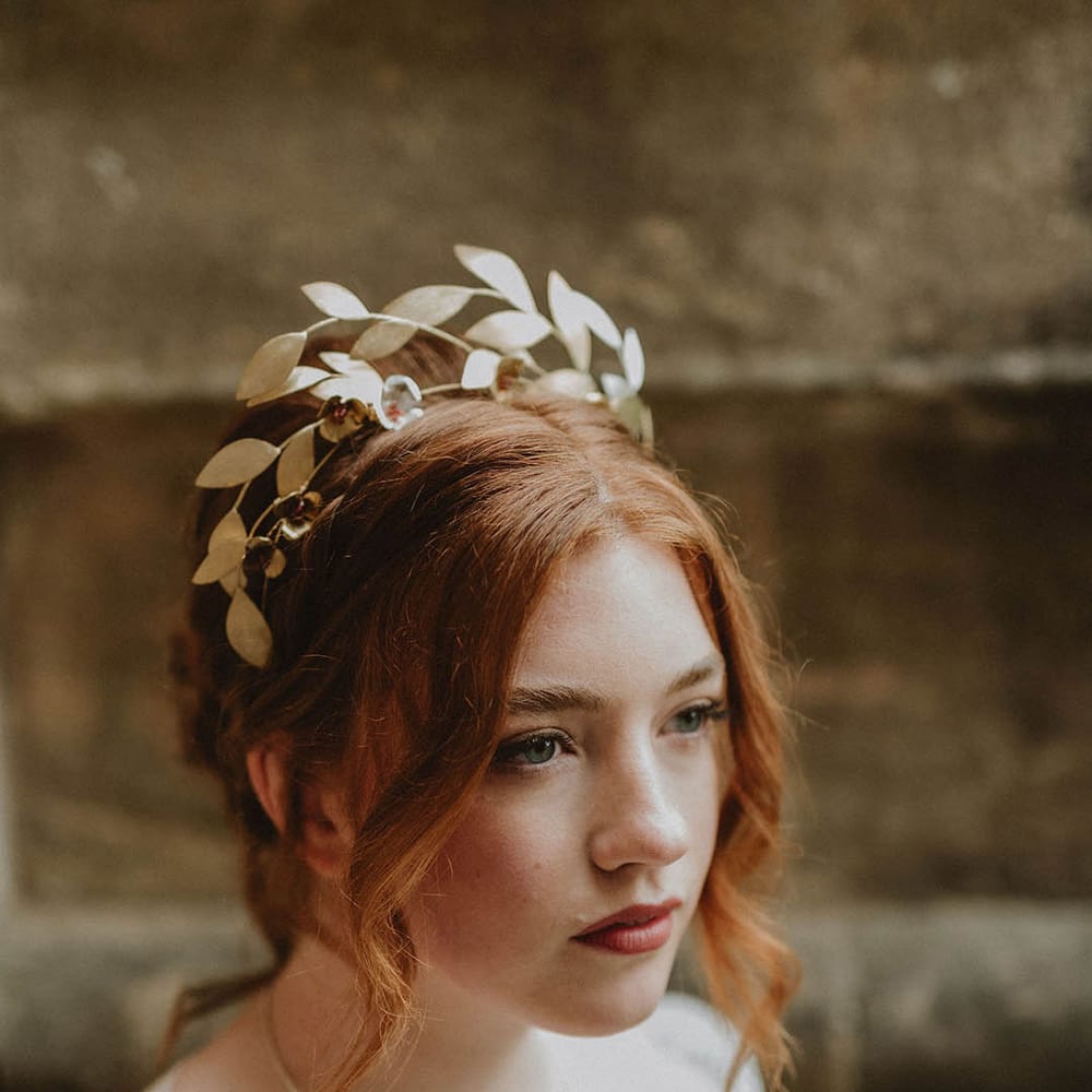 Bride with pinned up do wearing a gold leaf bridal crown headpiece 