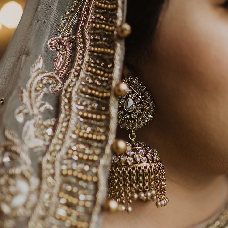 Muslim bride with gold earrings and embellished veil 