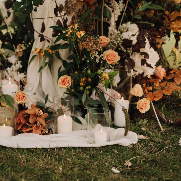 Orange and gold toned wedding flowers at the altar
