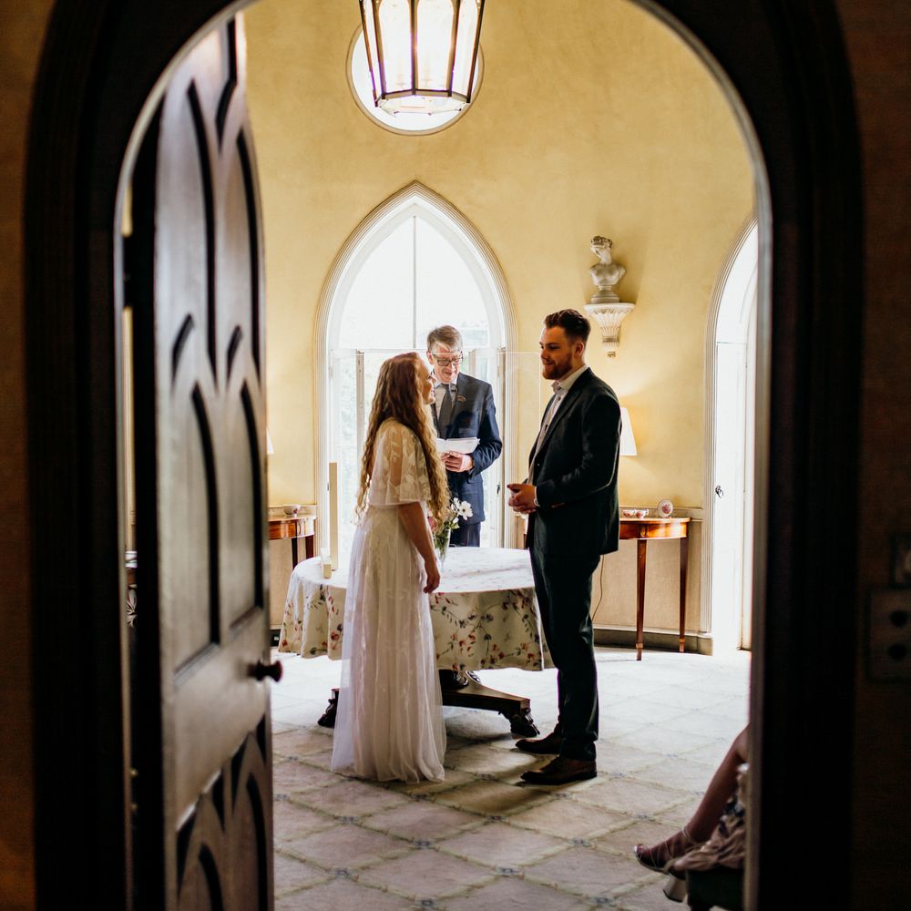 Bride & groom through doorway arch 