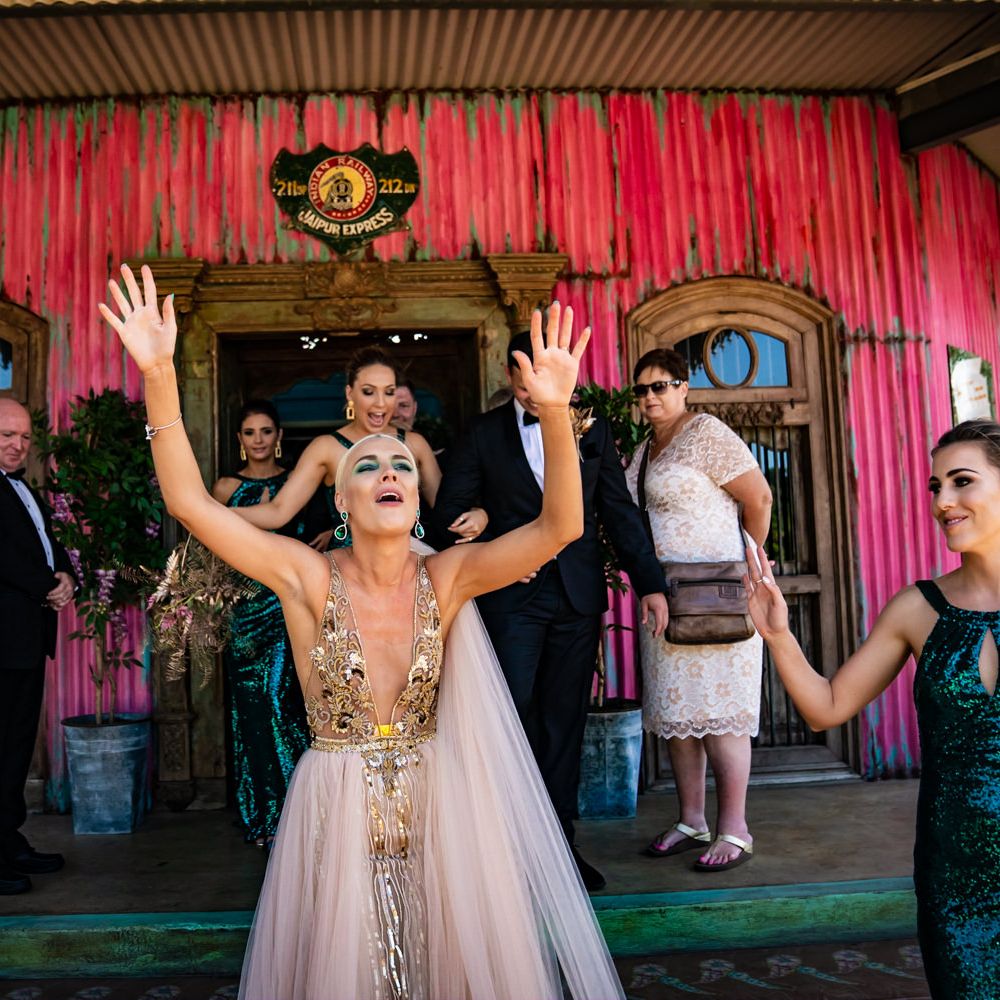Bride celebrates in white and gold wedding dress